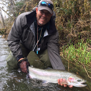 Guide Mike Bone holding a huge rainbow trout.